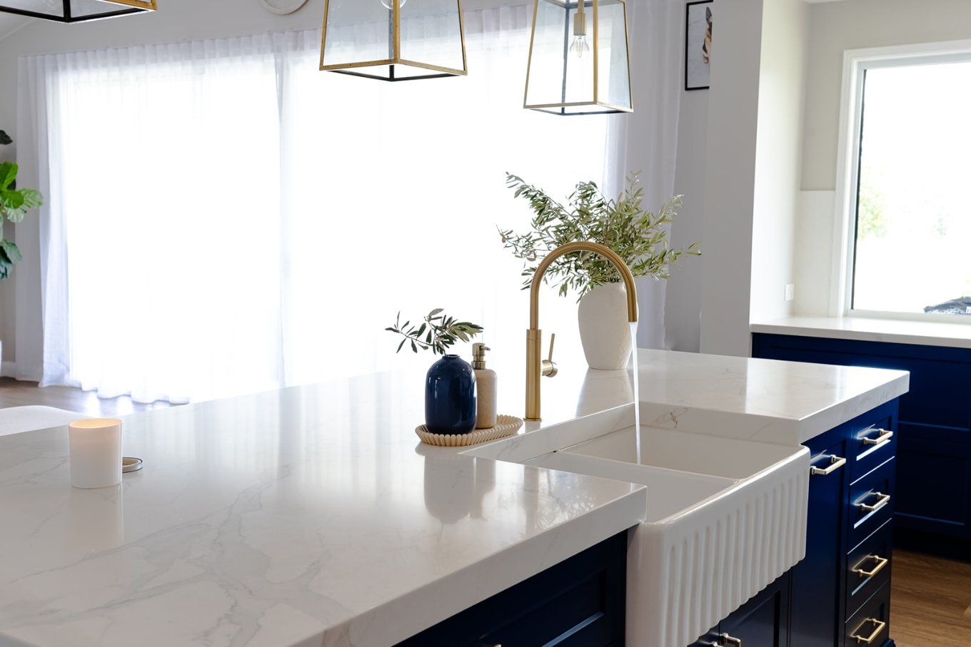 White and Blue Kitchen With a White Countertop, a Gold Faucet, and a Vase of Greenery — Truline Cabinets In Tuchekoi, QLD