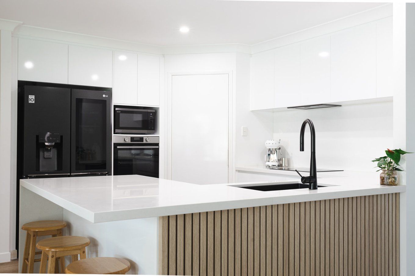 Modern White Kitchen With Black Appliances and a Light Wood Island — Truline Cabinets In Tuchekoi, QLD