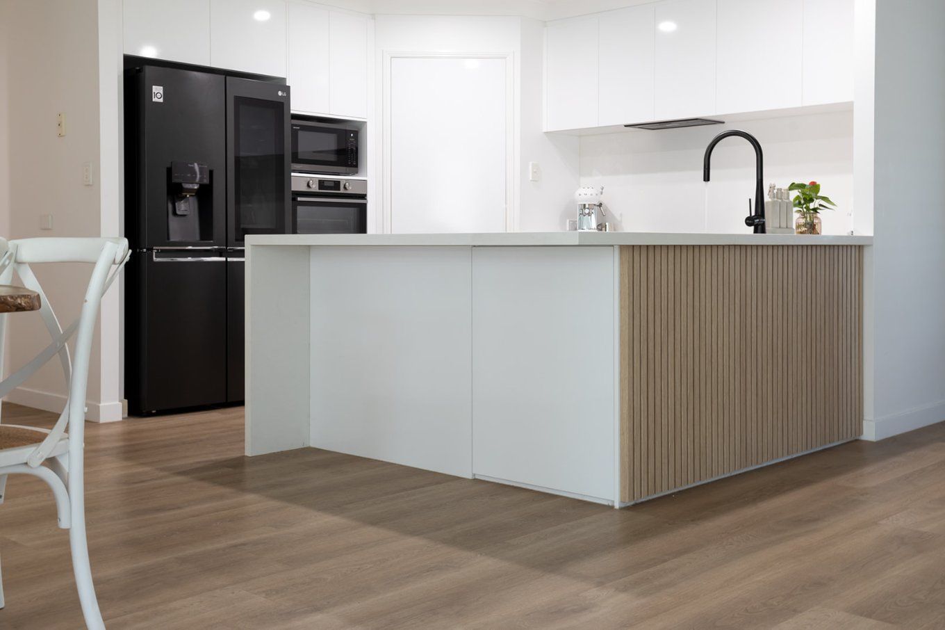 Modern Kitchen With White Cabinets and Black Appliances — Truline Cabinets In Tuchekoi, QLD
