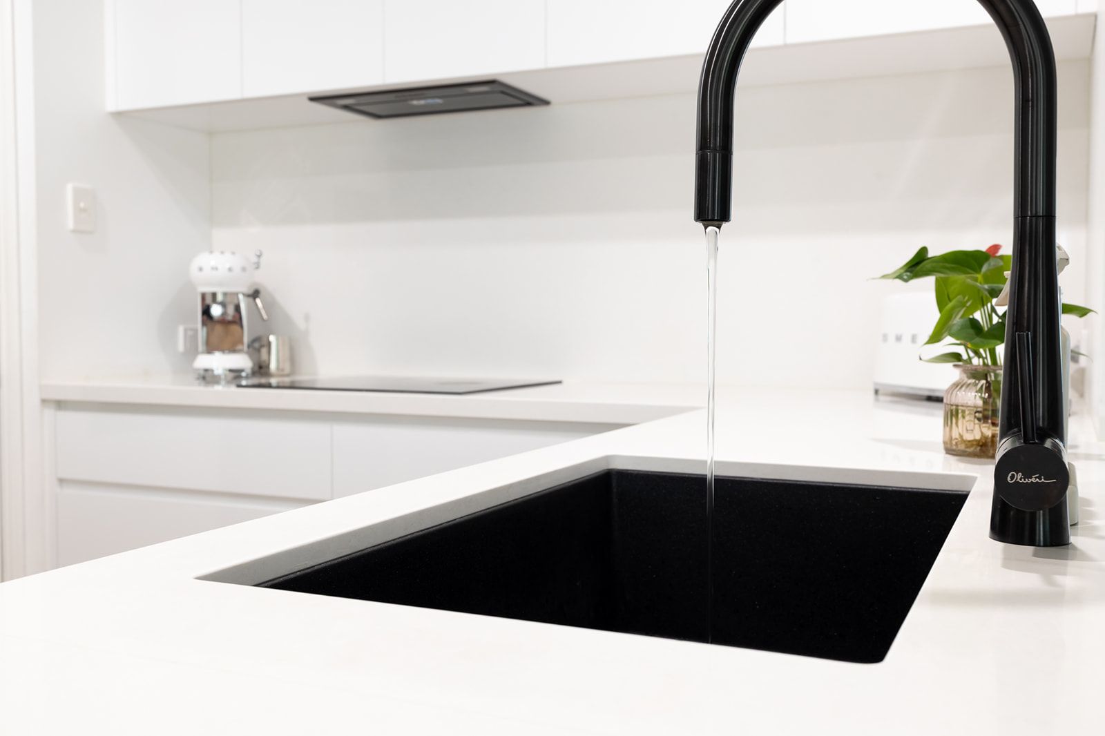 Black Kitchen Sink With Water Running From a Black Faucet — Truline Cabinets In Tuchekoi, QLD