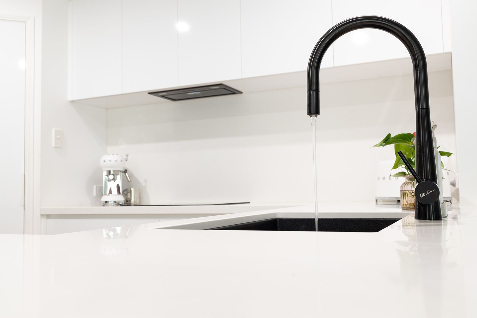 Black Faucet Over a Black Sink in a Modern White Kitchen — Truline Cabinets In Tuchekoi, QLD