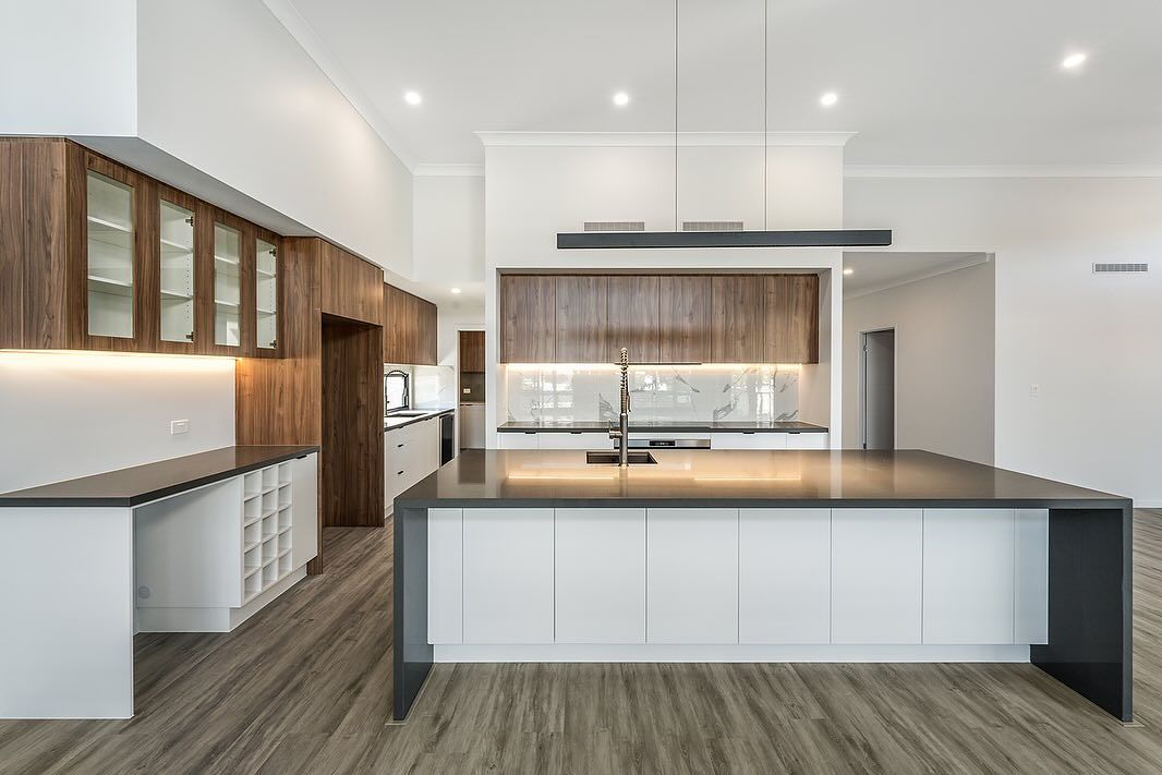 Modern Kitchen With a Large Island, Dark Countertops, White Cabinets, and Wood Accents — Truline Cabinets In Tuchekoi, QLD