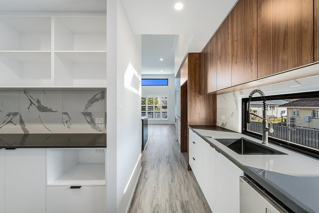 Modern Kitchen With White and Wood Cabinets, Marble Backsplash, and Long, Narrow Hallway — Truline Cabinets In Tuchekoi, QLD