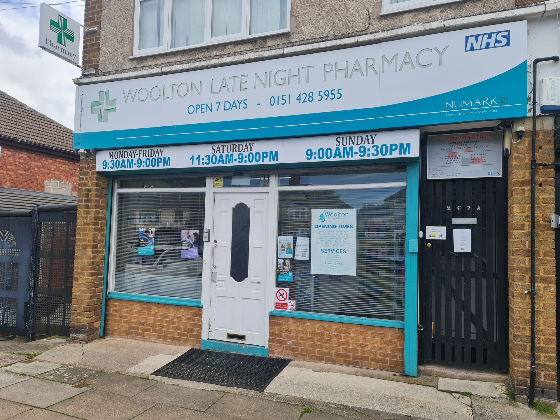 Woodson Lane Night Pharmacy storefront with blue sign, white door, and NHS logo on the facade