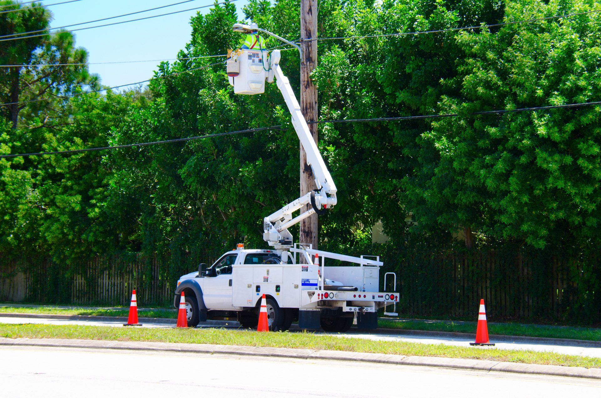 A man is working on fiber optic cabling from a bucket truck