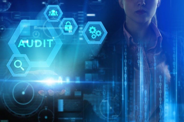 A woman is looking at a futuristic screen with the word audit on it.