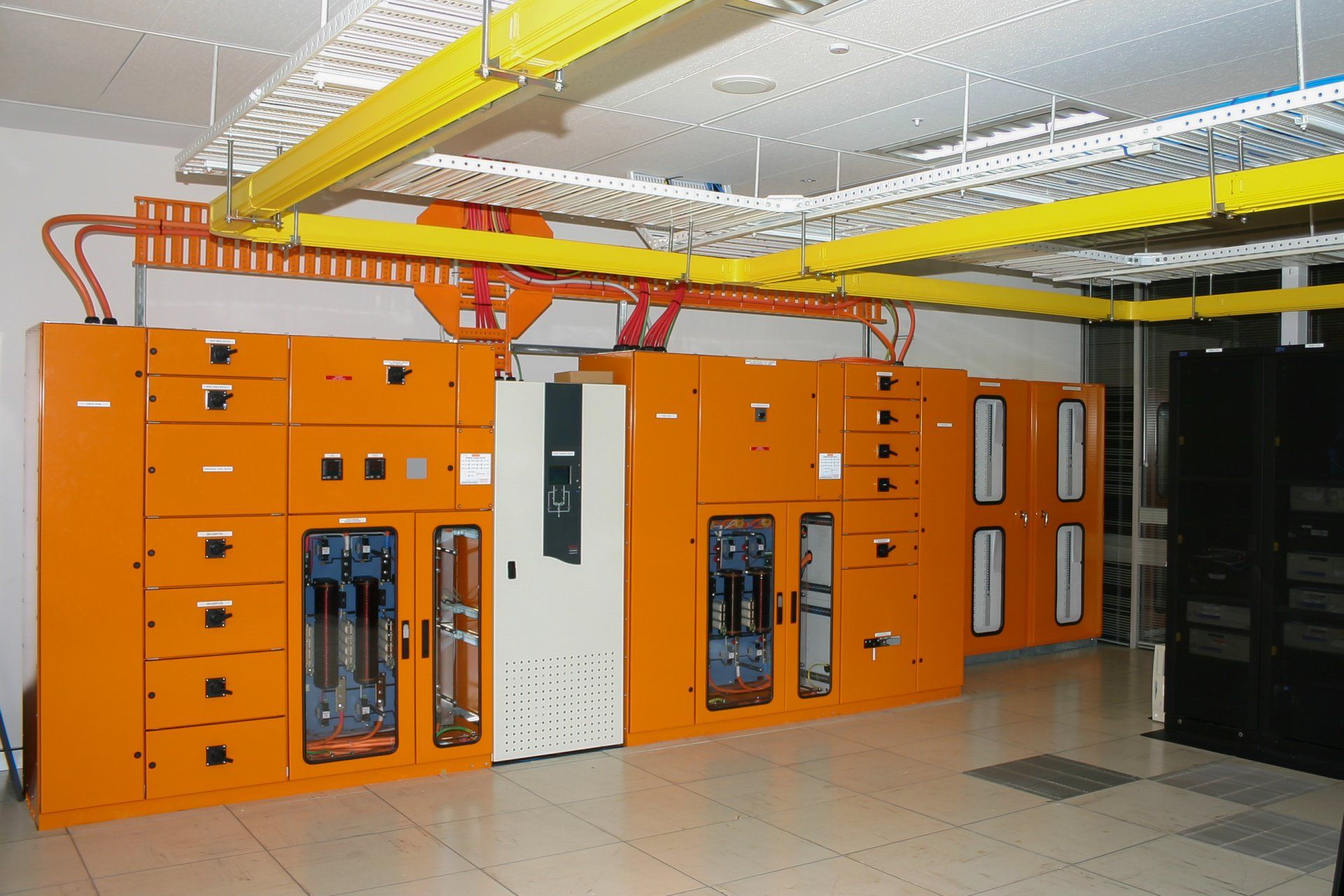 A room with lots of orange DC Power cabinets 
