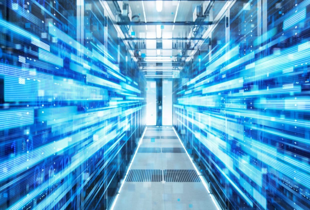 A hallway in a data center filled with lots of servers.