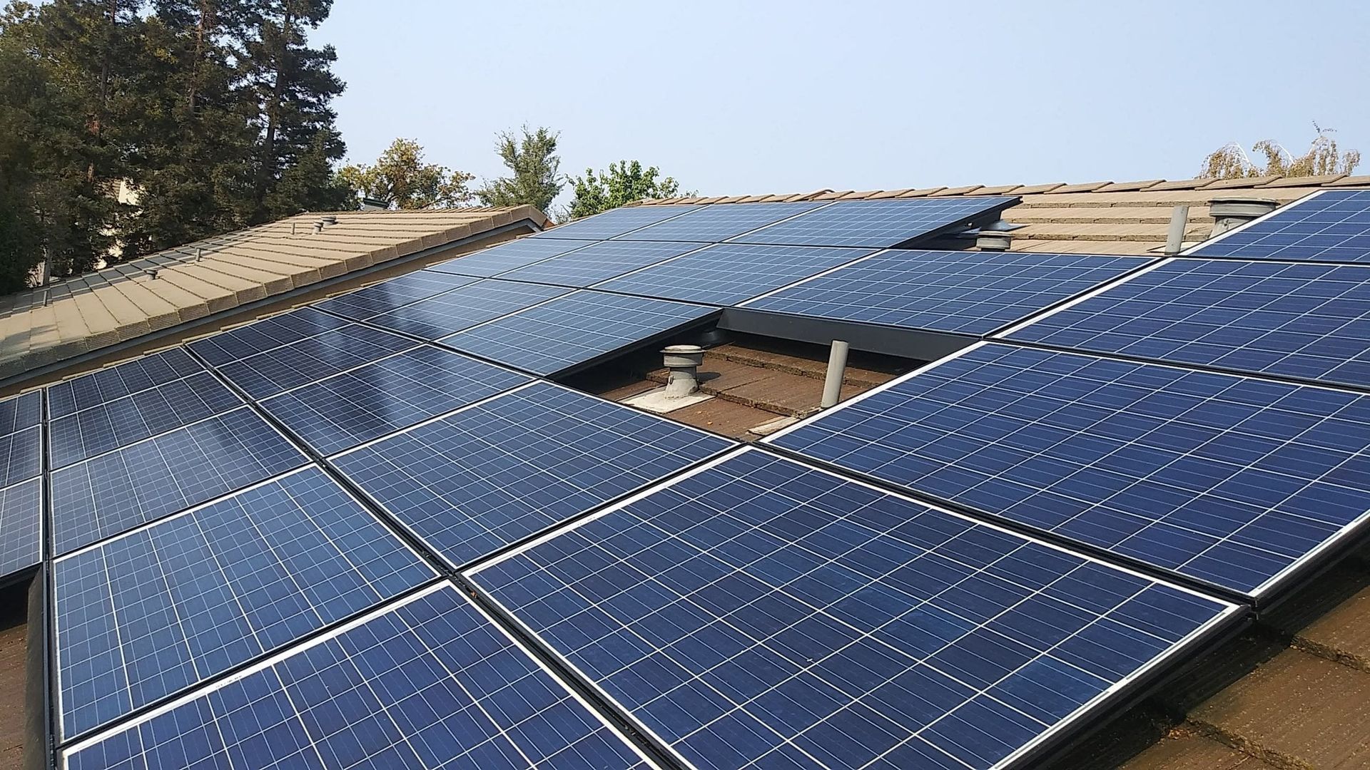 Solar panels installed on a residential roof, angled toward the sun.