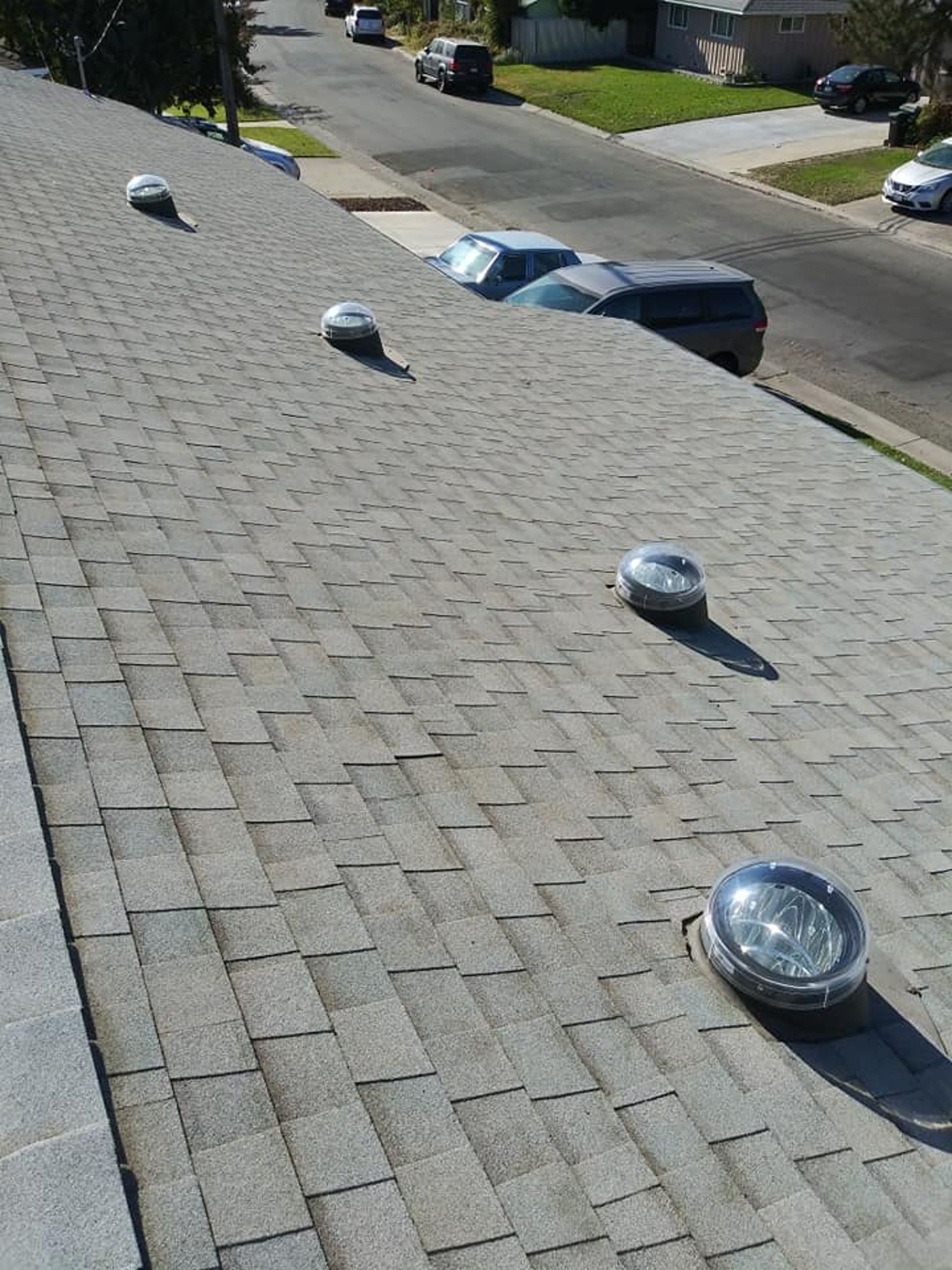Gray shingled roof with four circular vents.