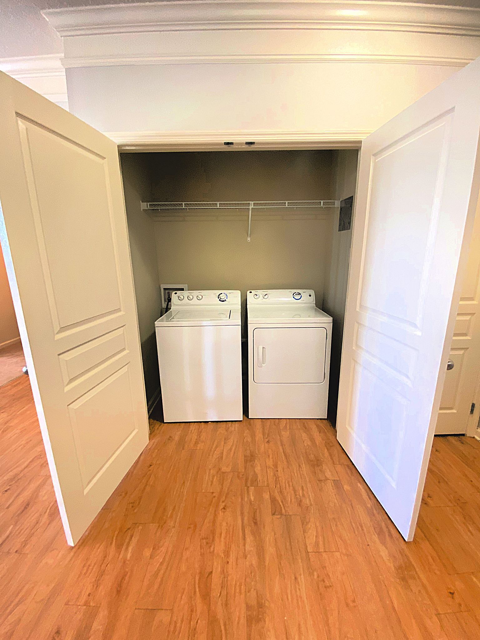 Open closet with white washer and dryer on a wood floor at Grand Oaks at Ogeechee River in Savannah, GA.