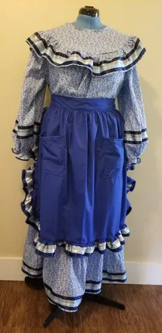 A blue dress with ruffles and an apron is on a mannequin.