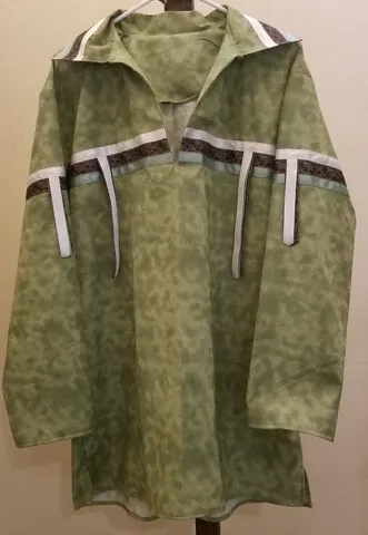 A green shirt with a hood is hanging on a hanger.