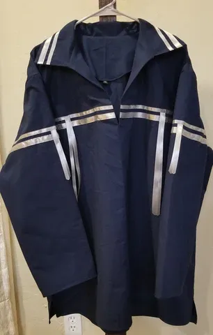 A blue jacket with white stripes on the sleeves is hanging on a hanger.