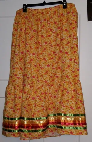 A yellow skirt with red and green ribbons is hanging on a hanger.