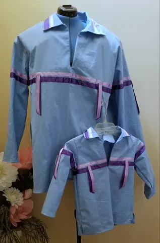 A man and a child are wearing matching shirts on a mannequin.