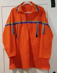An orange shirt is hanging on a white door