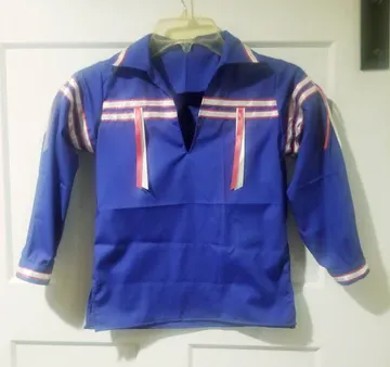 A blue shirt with red white and blue stripes is hanging on a door