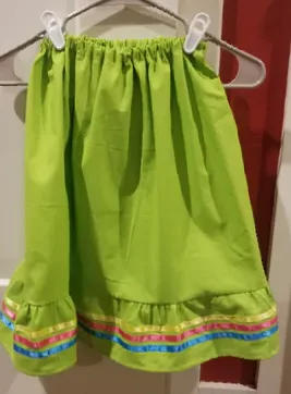 A green dress is hanging on a white hanger