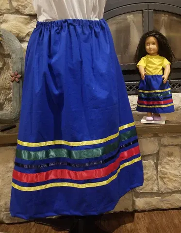 A doll wearing a blue skirt is standing next to a woman wearing a blue skirt
