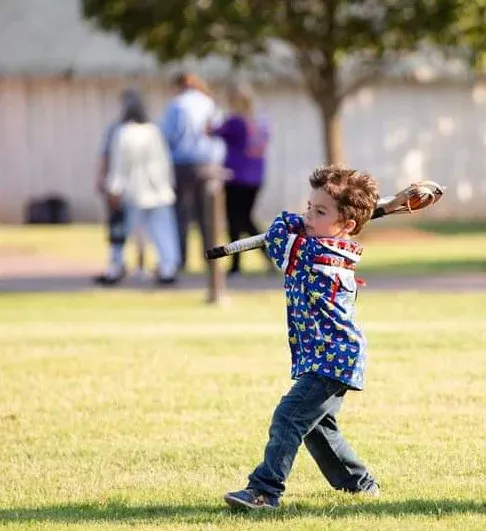 A young boy is throwing a baseball in a park