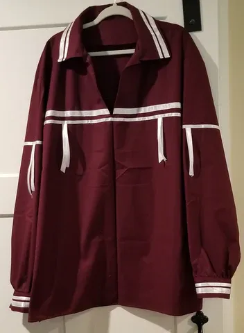 A maroon jacket with white stripes is hanging on a hanger