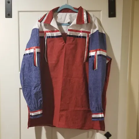 A red white and blue jacket is hanging on a hanger