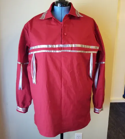 A red shirt with silver stripes on the sleeves is on a mannequin