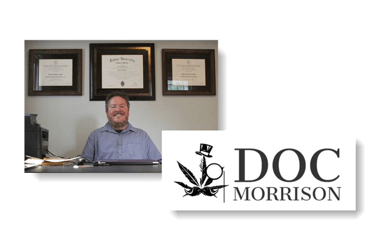 A man is sitting at a desk next to a sign that says doc morrison