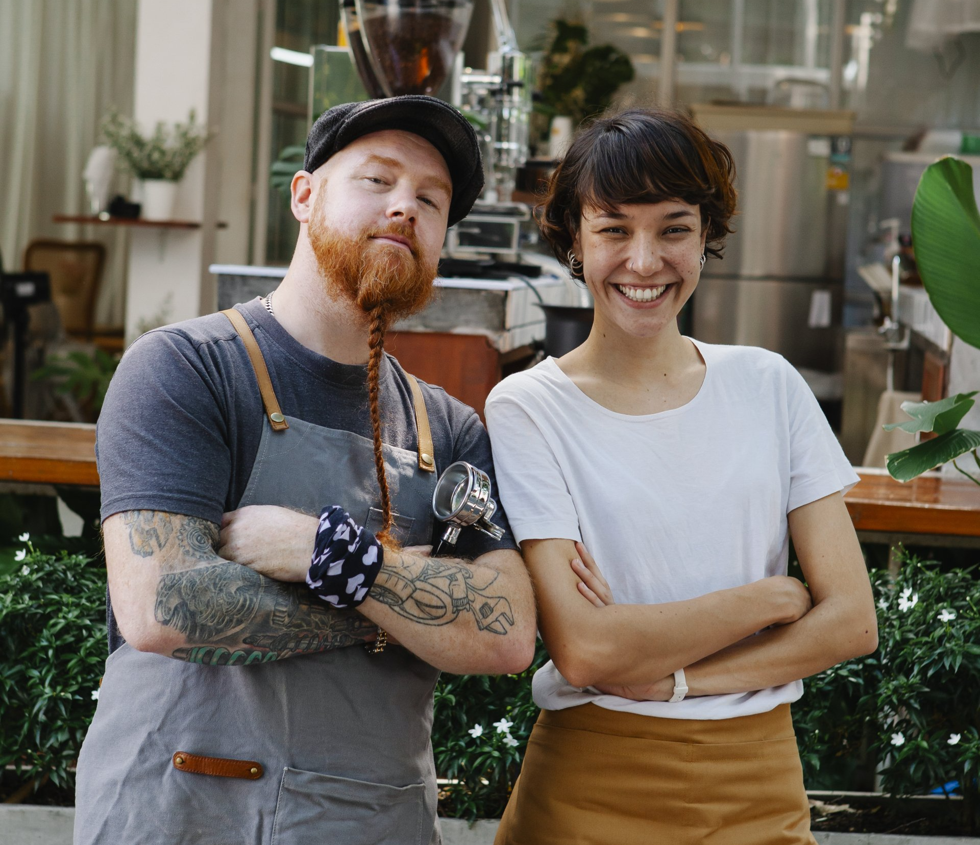 A man and a woman are posing for a picture with their arms crossed