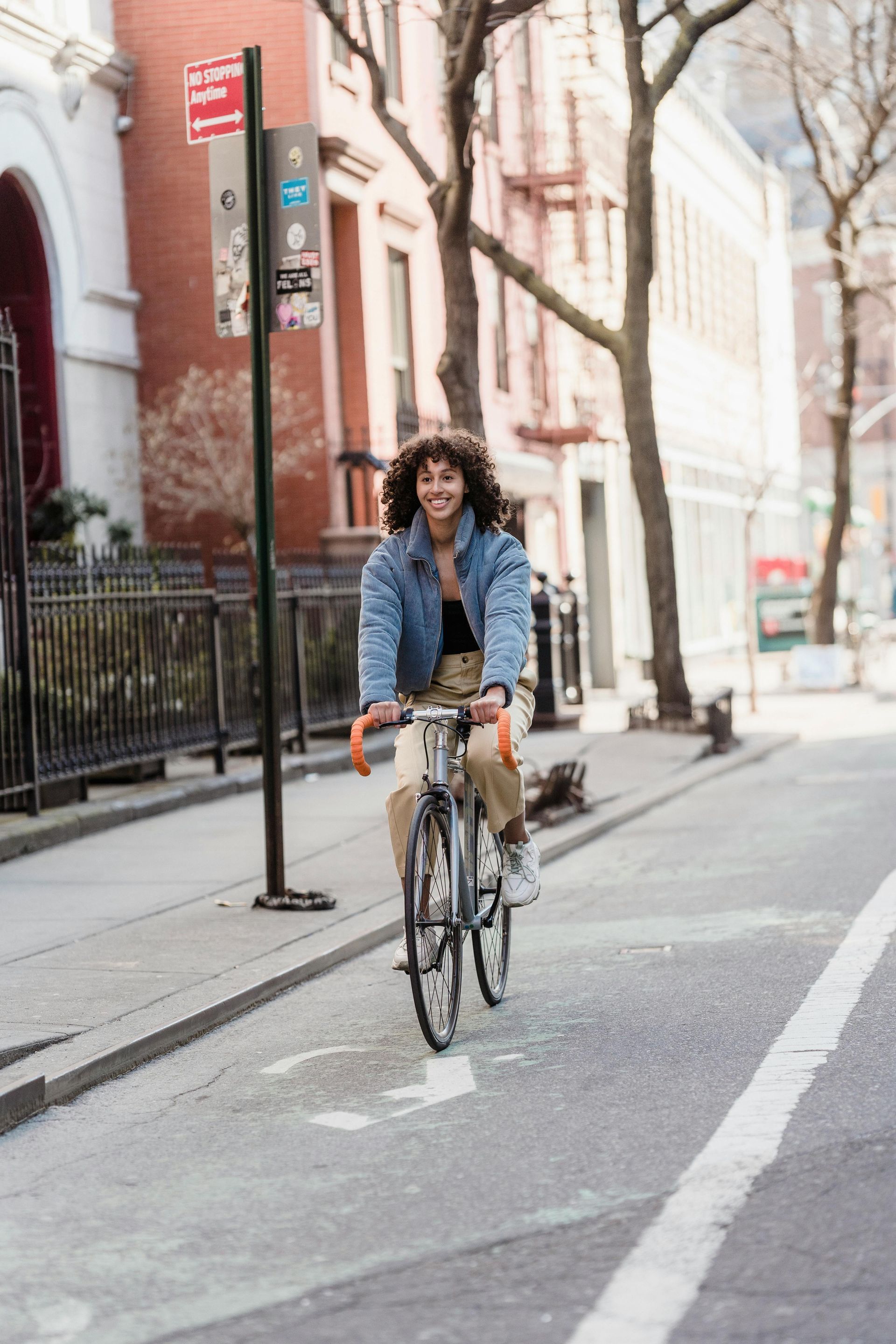 A woman is riding a bike down a city street.