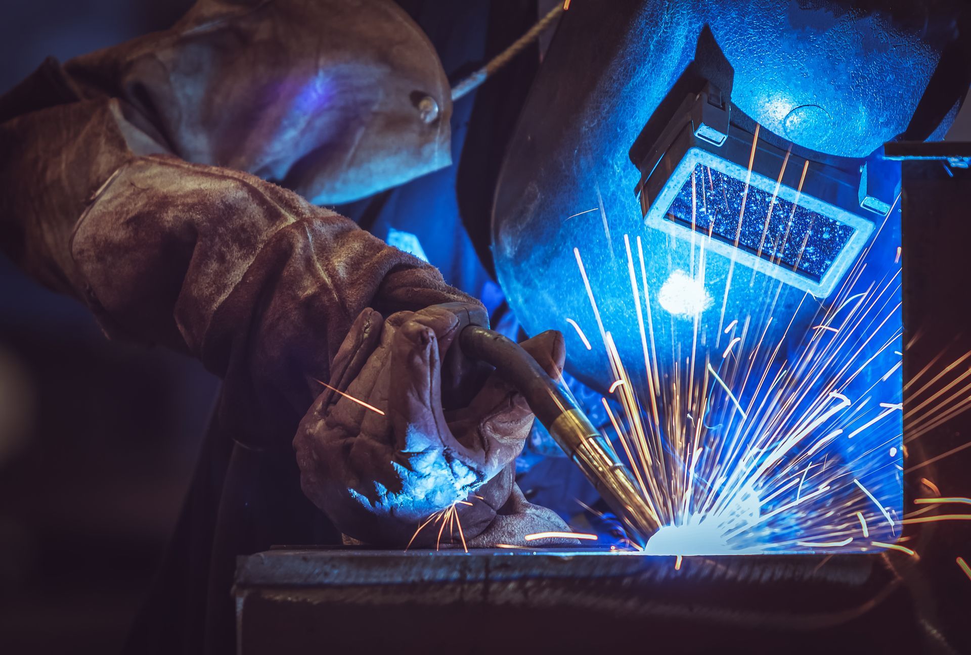 A man is welding a metal structure on top of a building.