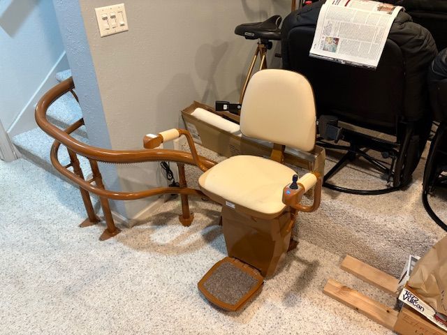 A stair lift is in front of a spiral staircase