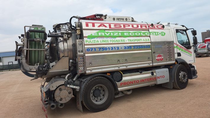 Camion dei pompieri bianco e rosso parcheggiato su una strada bagnata con tubi e attrezzature sul tetto