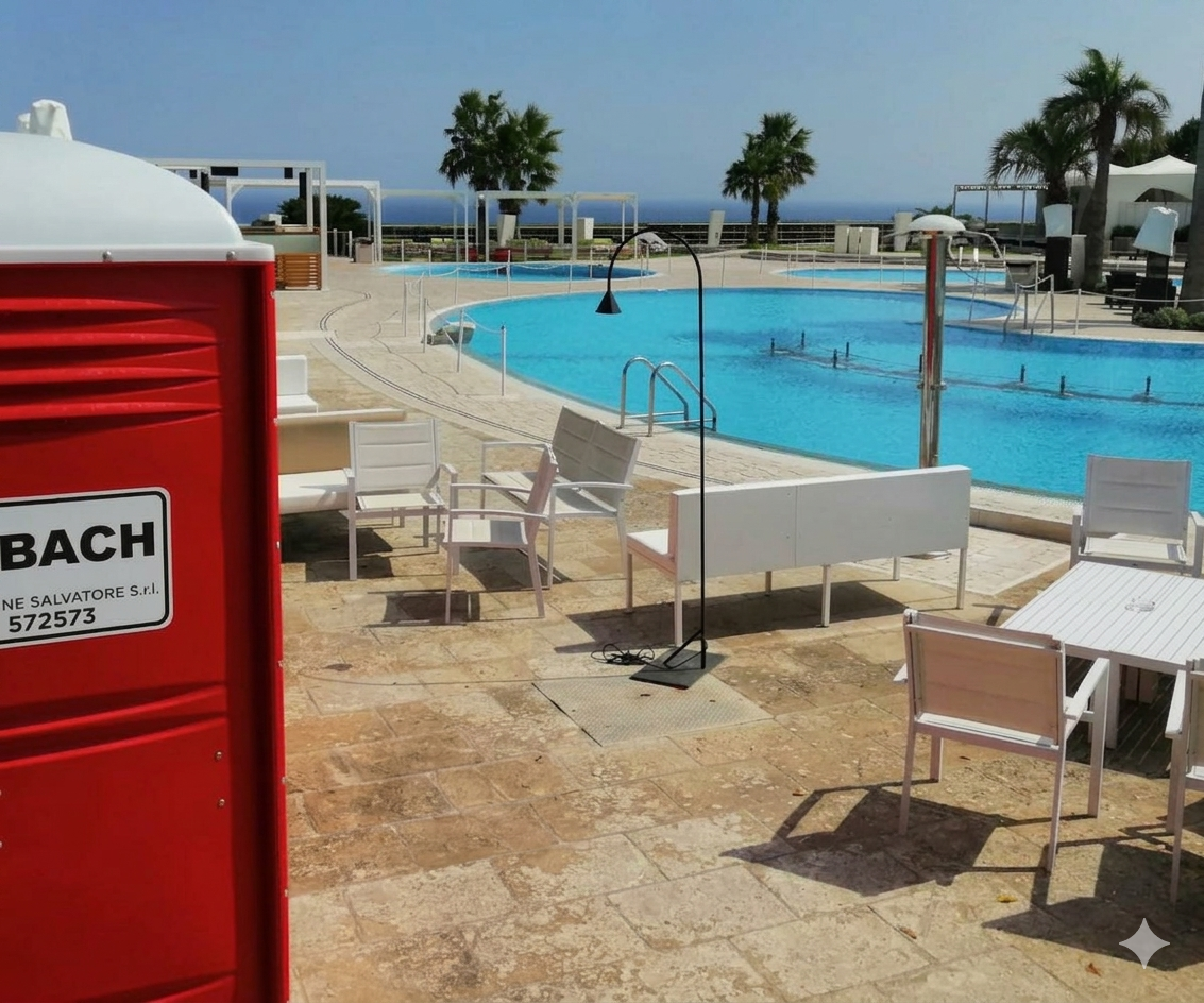 Postazione di salvataggio rossa accanto alla piscina di un resort con lettini bianchi e palme in riva al mare.