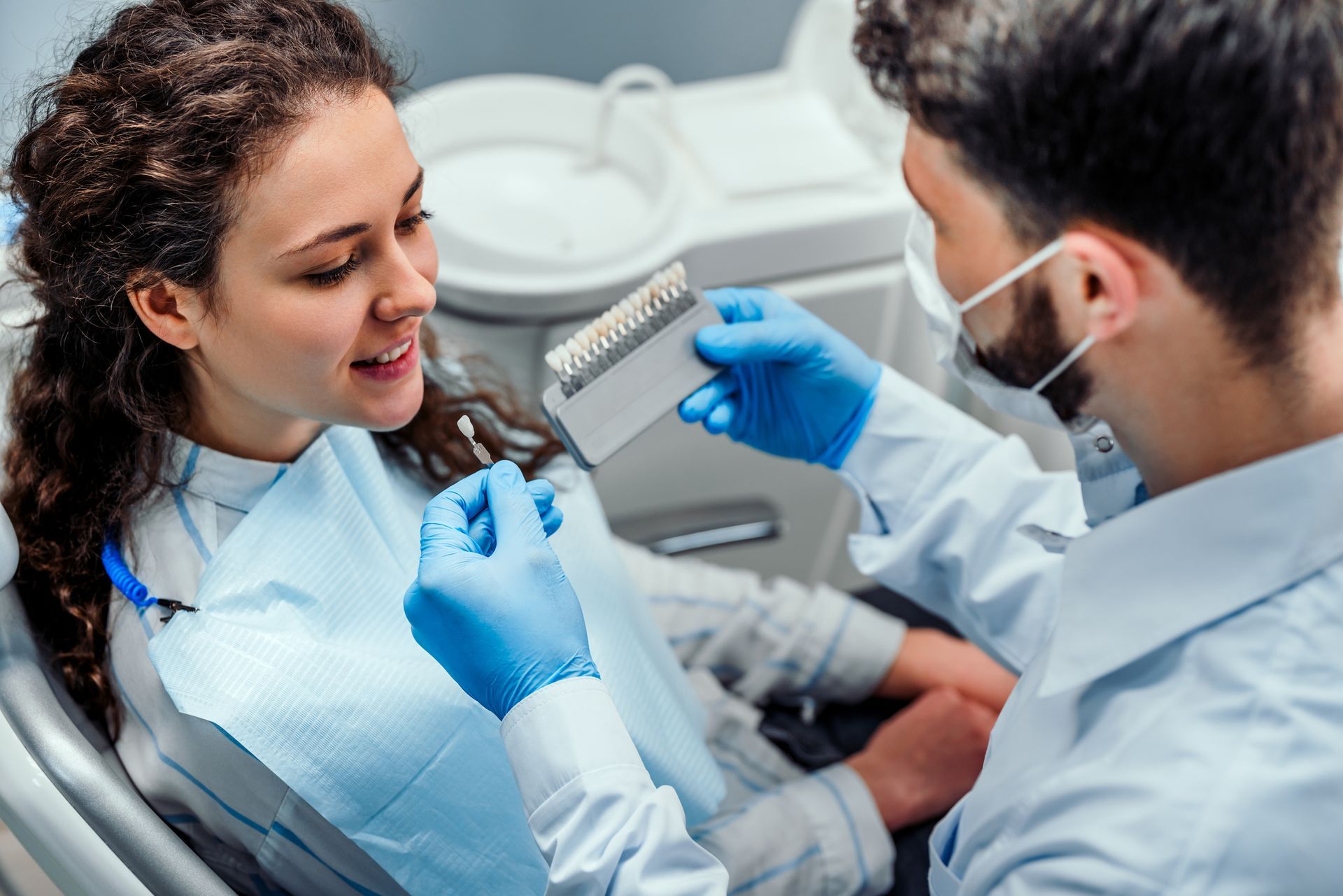 A woman receives a dental cleaning at Plaza Dental Offices in Memphis, TN, with a male dentist focus
