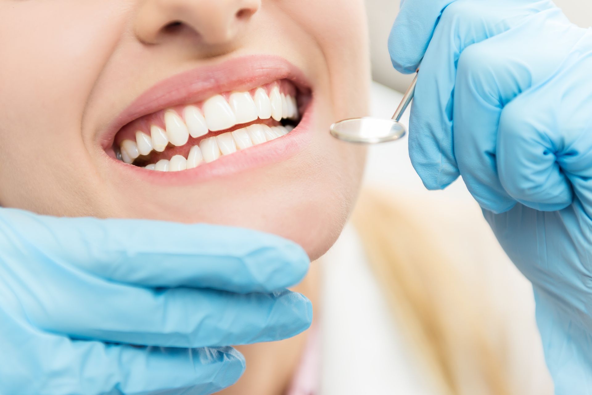 Close-up of woman undergoing dental examination by dentist in clinic.