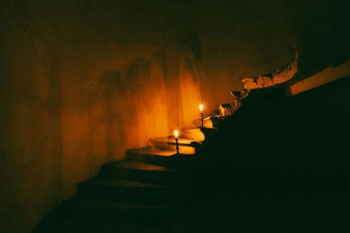 The stairs are lit up with candles in the dark.