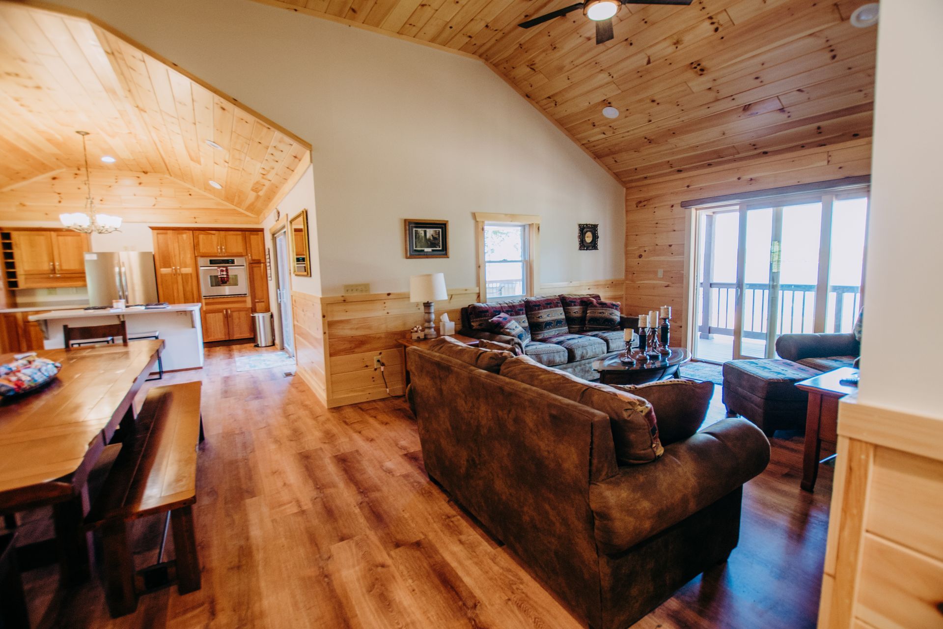 A living room filled with furniture and a ceiling fan in a log cabin.