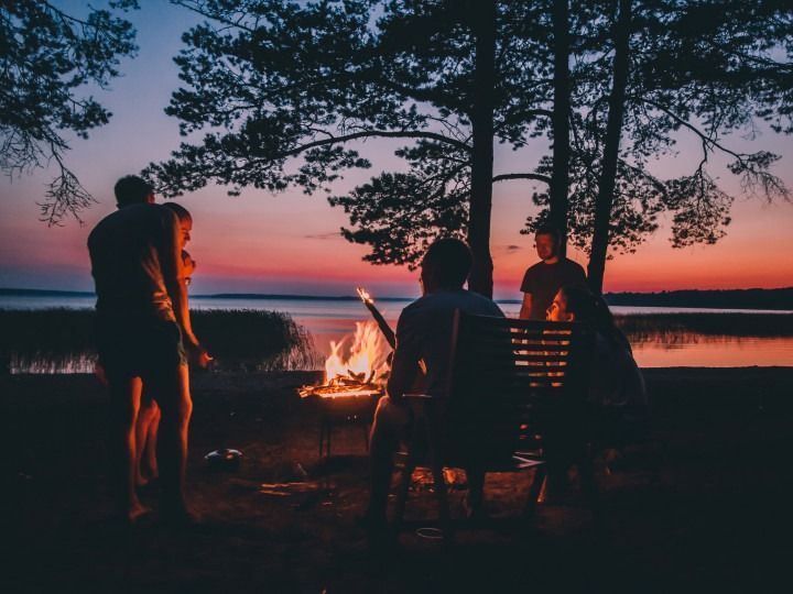 A group of people are sitting around a campfire.