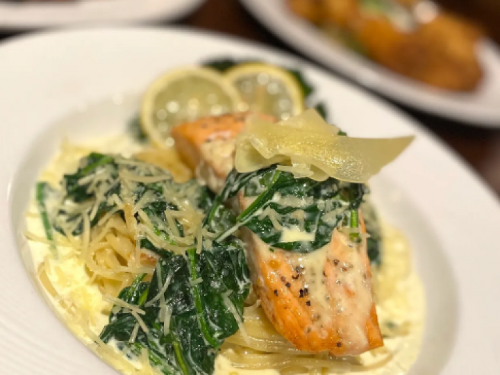 A close up of a plate of food with salmon and spinach