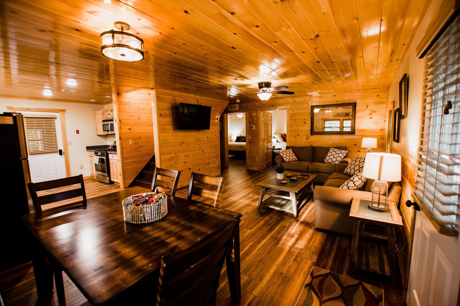 A living room with a dining table and chairs in a cabin.