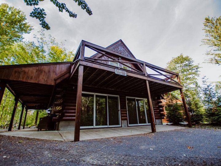 A log cabin with a large deck in the woods