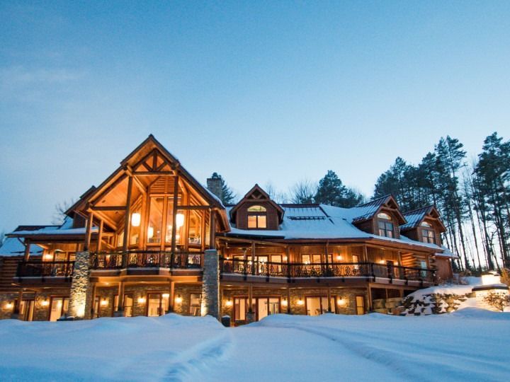 A large house with a lot of windows is covered in snow
