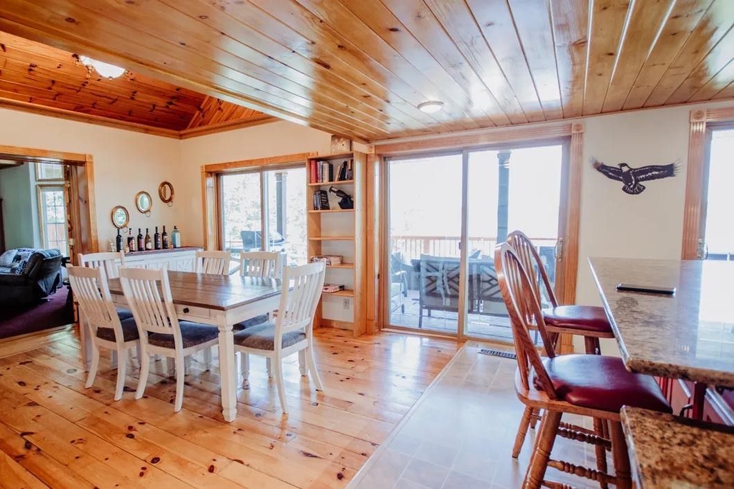 A living room with a dining table and chairs and a bar.