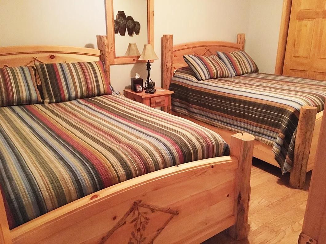 A bedroom with two beds and a mirror