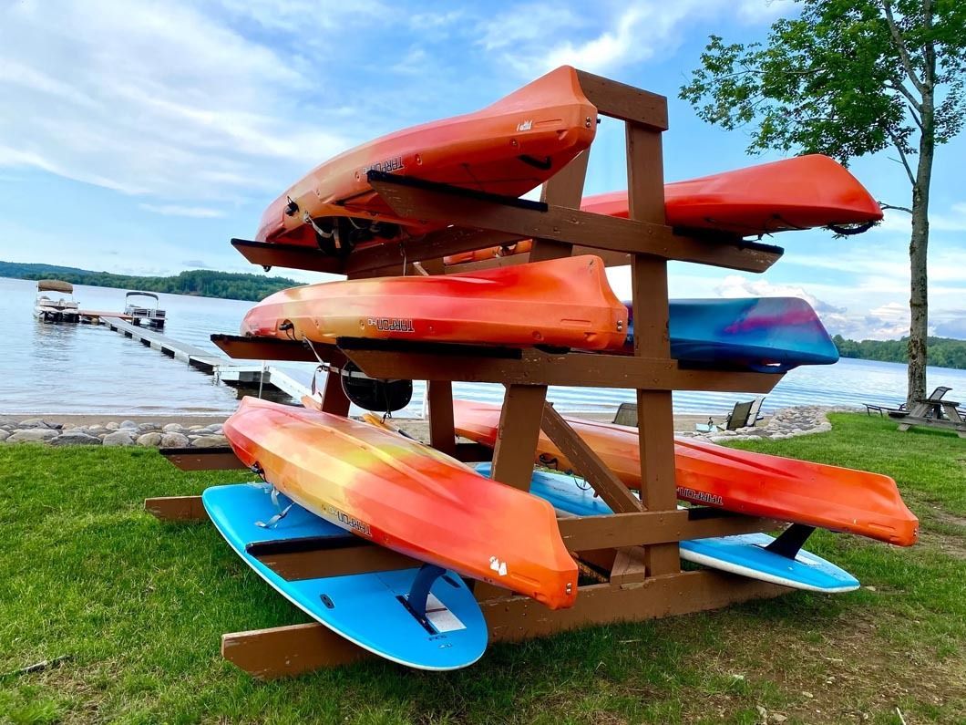 A wooden rack filled with kayaks and surfboards.