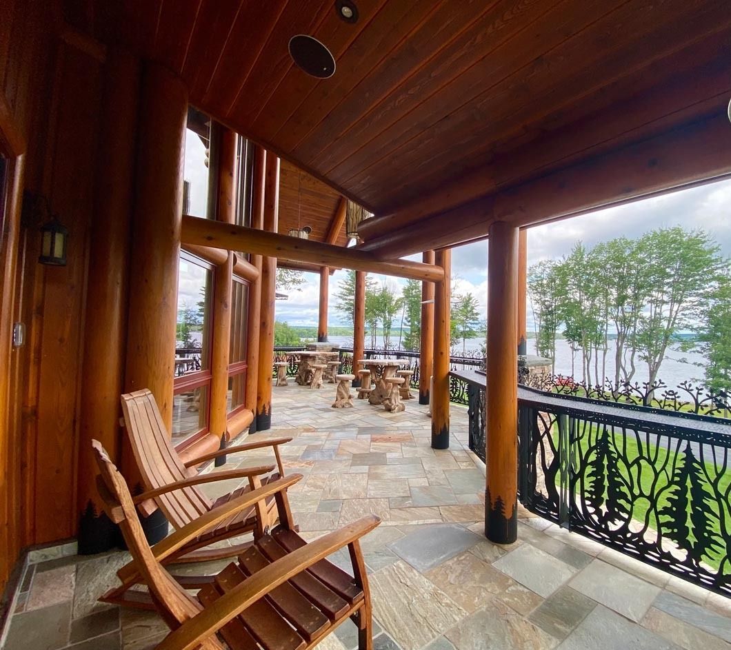 There are two rocking chairs on the porch of a house.