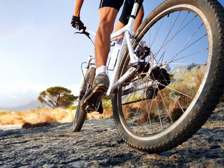 A person is riding a bike on a dirt road.