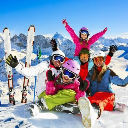 A group of skiers are posing for a picture in the snow